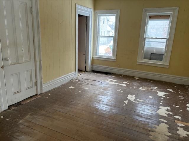 spare room featuring plenty of natural light and dark hardwood / wood-style flooring