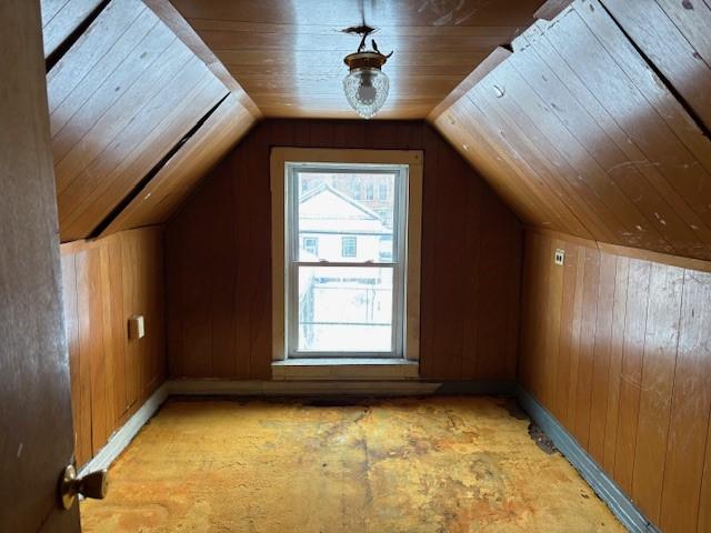 bonus room featuring lofted ceiling, wooden ceiling, and wooden walls