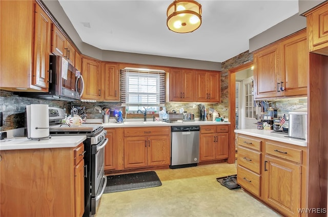 kitchen with appliances with stainless steel finishes, sink, and decorative backsplash