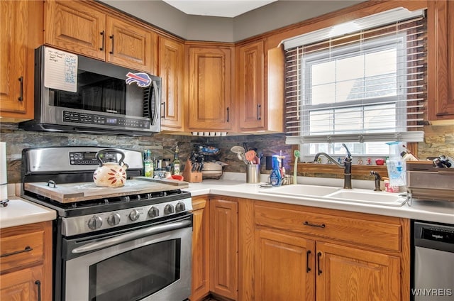 kitchen with tasteful backsplash, appliances with stainless steel finishes, and sink