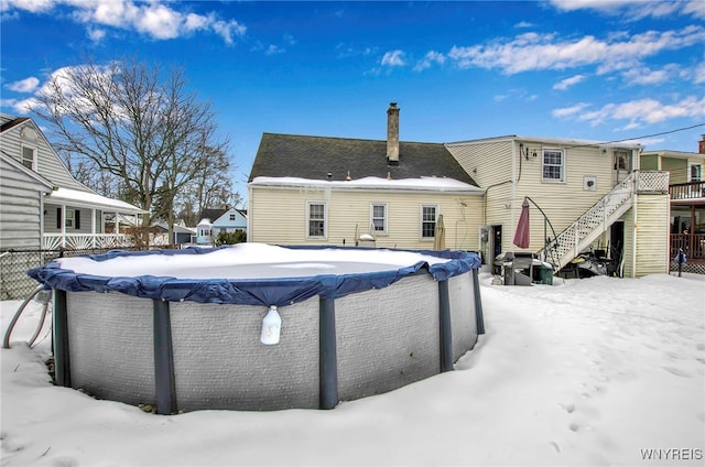 snow covered property featuring a covered pool