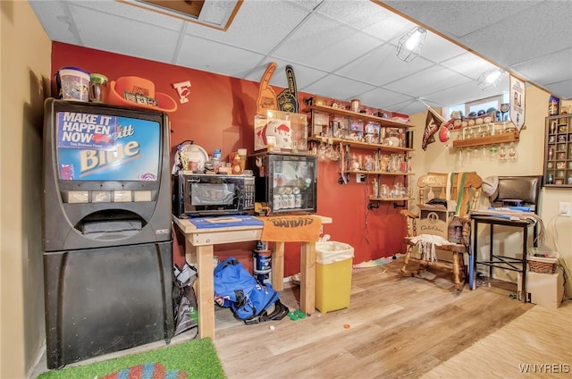 interior space featuring a paneled ceiling and hardwood / wood-style floors