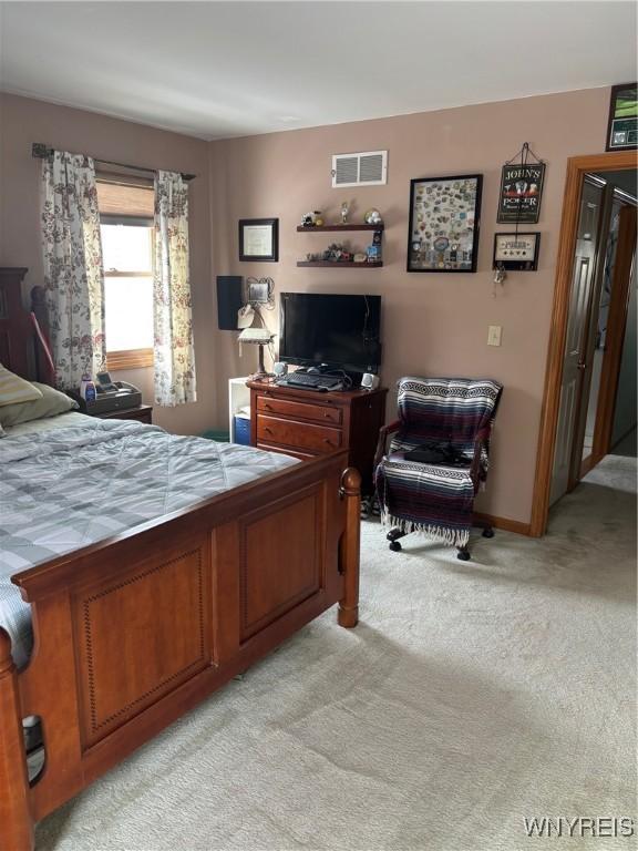 bedroom with visible vents, baseboards, and light colored carpet