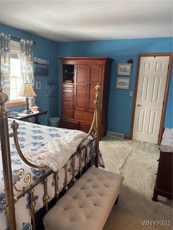 bedroom featuring light colored carpet and baseboards