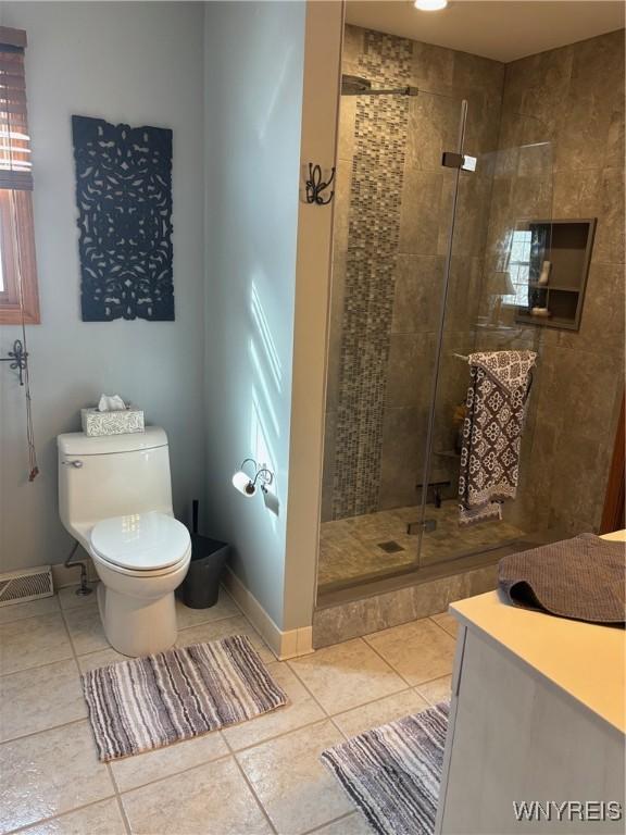 bathroom featuring a shower stall, tile patterned flooring, visible vents, and toilet