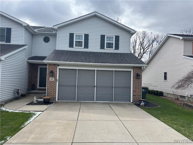 traditional-style home featuring roof with shingles, a front lawn, brick siding, an attached garage, and driveway