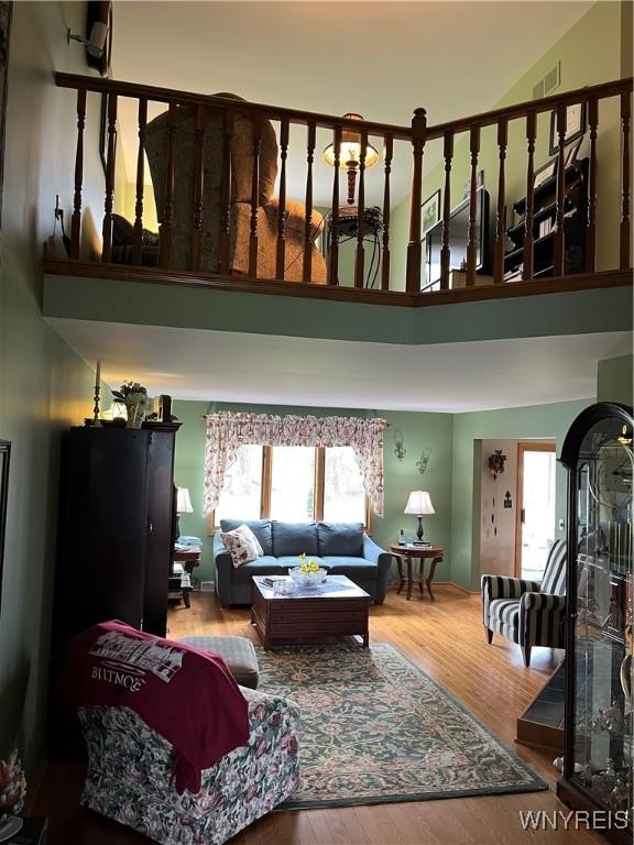 living area with plenty of natural light, a high ceiling, and wood finished floors