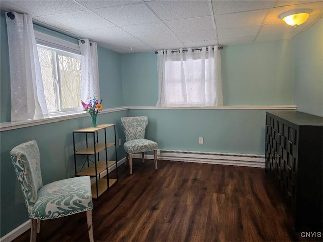 sitting room with a paneled ceiling, dark hardwood / wood-style floors, and a baseboard heating unit