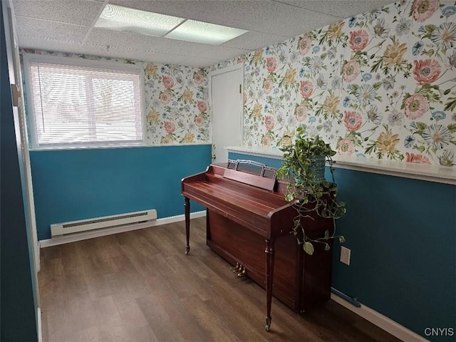 miscellaneous room featuring baseboard heating, a paneled ceiling, and hardwood / wood-style flooring