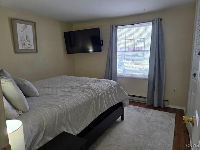 bedroom with a baseboard radiator and hardwood / wood-style floors