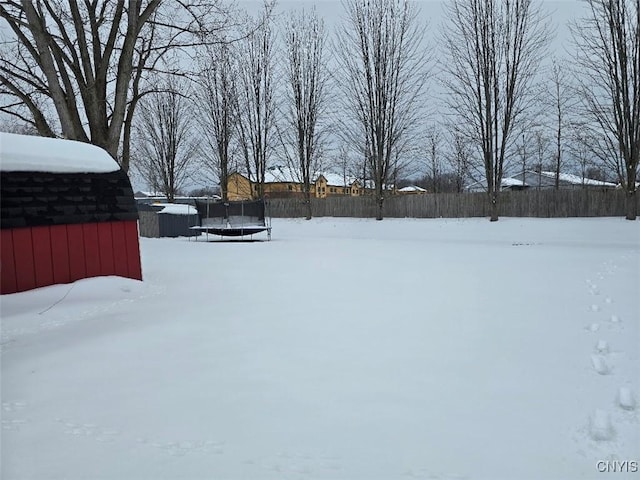 snowy yard featuring a trampoline