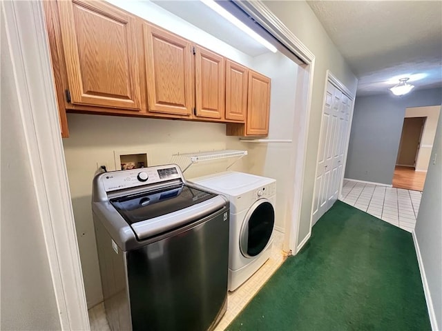 washroom featuring cabinets, separate washer and dryer, and dark tile patterned floors