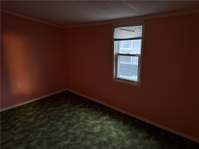 spare room with crown molding, dark carpet, and a textured ceiling