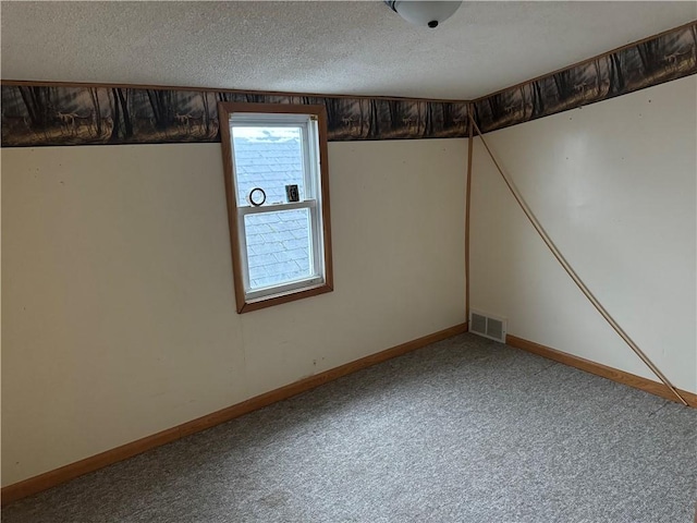 basement featuring a textured ceiling and carpet flooring