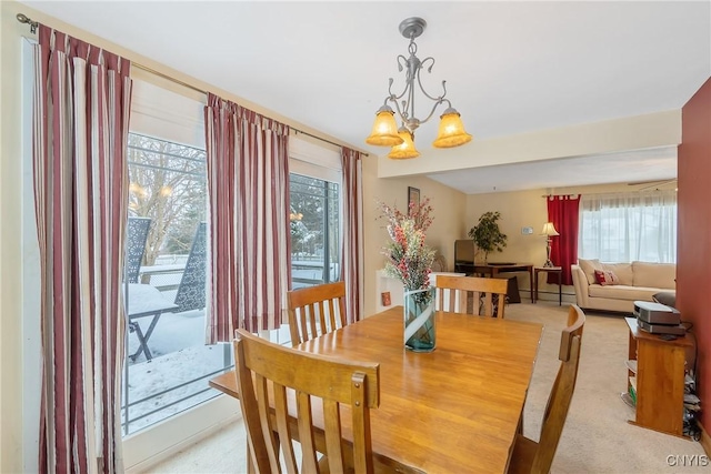 carpeted dining room with a chandelier