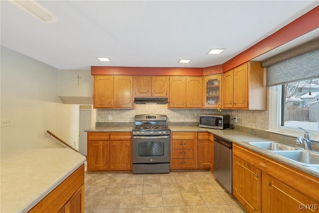 kitchen with sink, decorative backsplash, light tile patterned floors, and appliances with stainless steel finishes