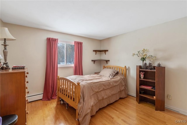 bedroom with baseboard heating and light wood-type flooring