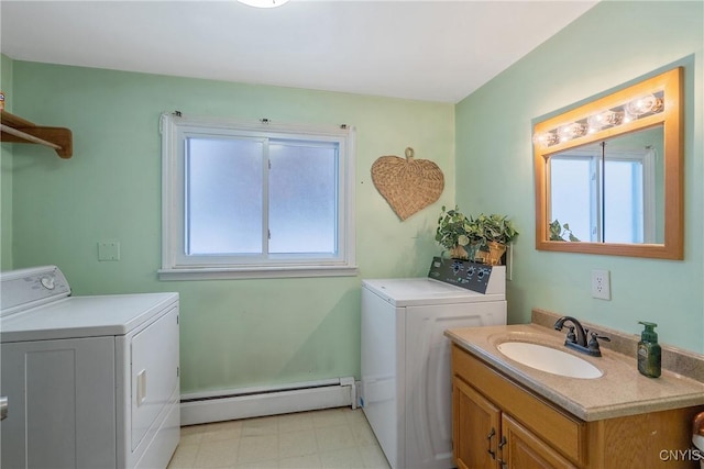 washroom featuring a baseboard heating unit, sink, and washer and dryer