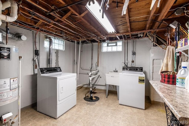 laundry area featuring water heater, sink, and independent washer and dryer