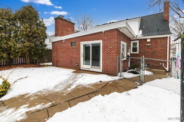 view of snow covered back of property