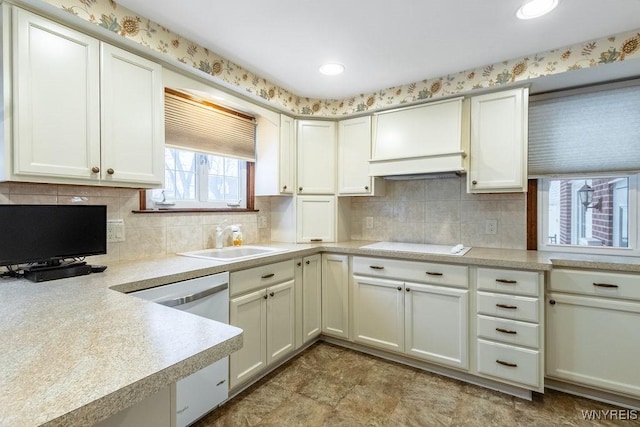 kitchen featuring white cooktop, extractor fan, sink, dishwashing machine, and backsplash