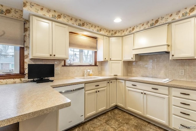 kitchen with dishwashing machine, sink, white stovetop, decorative backsplash, and custom exhaust hood