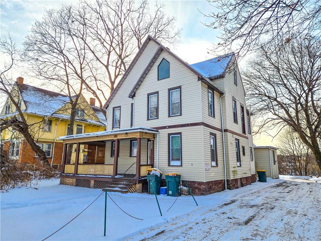 snow covered rear of property with covered porch