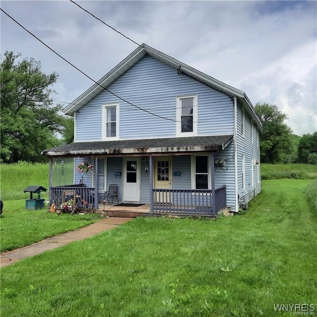 back of house with covered porch and a yard