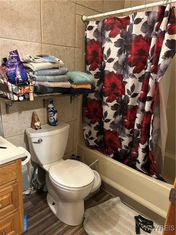 bathroom with shower / bath combo with shower curtain, toilet, and tile walls