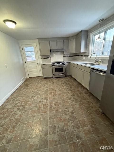 kitchen with pendant lighting, stainless steel appliances, gray cabinets, and sink