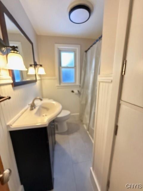 bathroom featuring vanity, a shower with curtain, tile patterned floors, and toilet