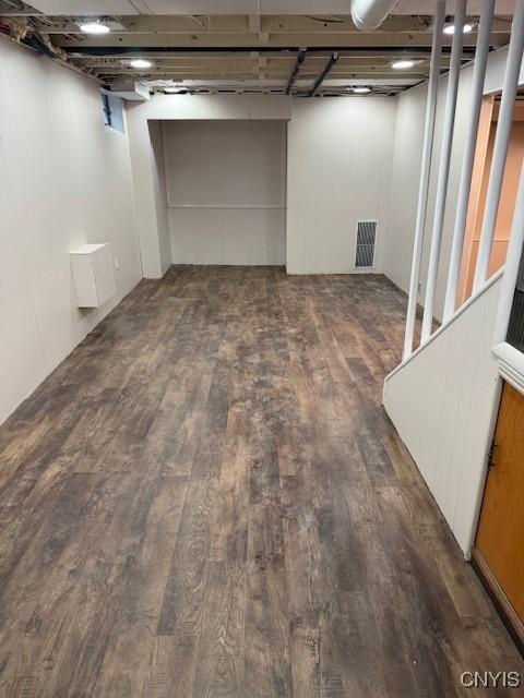 basement with dark hardwood / wood-style flooring