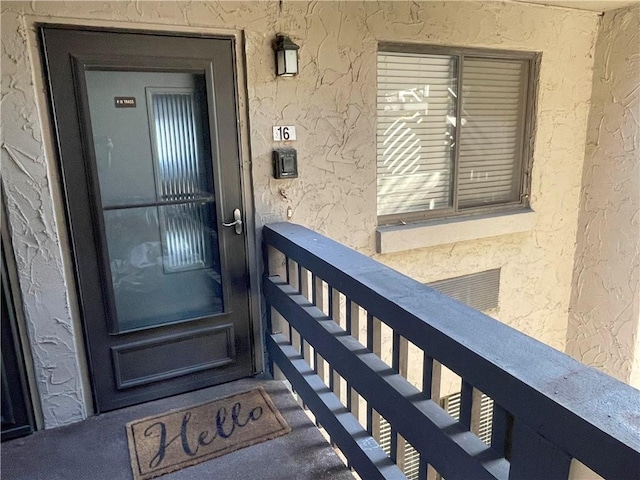 view of exterior entry with a balcony