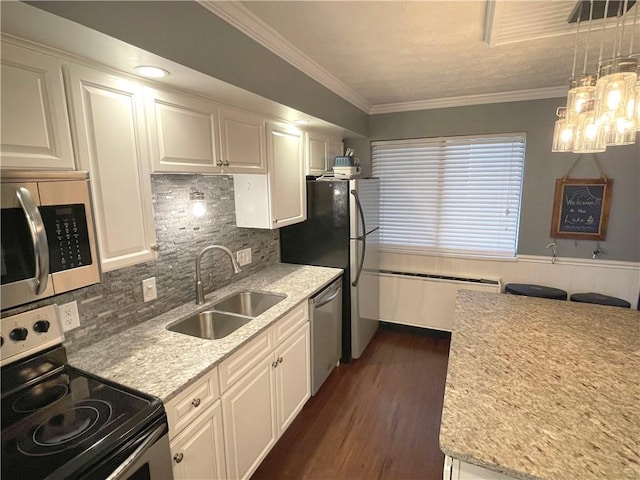 kitchen featuring white cabinetry, appliances with stainless steel finishes, decorative light fixtures, and sink