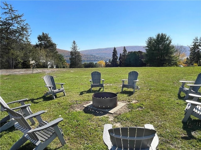 view of yard featuring an outdoor fire pit and a mountain view