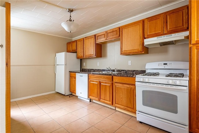 kitchen featuring sink, hanging light fixtures, light tile patterned floors, white appliances, and dark stone counters