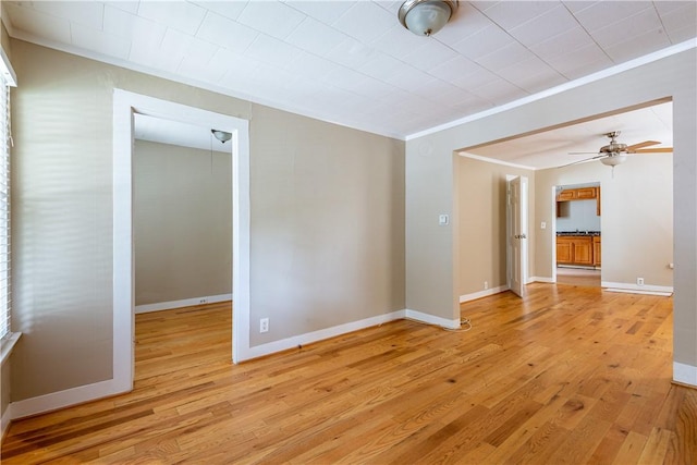 spare room featuring ornamental molding, ceiling fan, and light hardwood / wood-style flooring