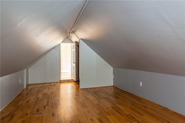 bonus room with vaulted ceiling and light hardwood / wood-style floors