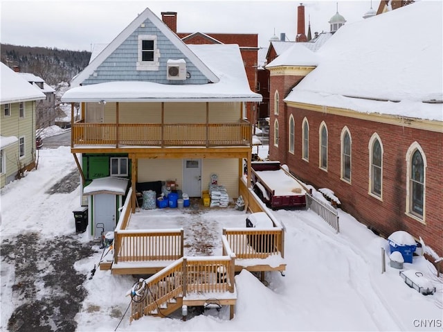 snow covered house featuring a deck