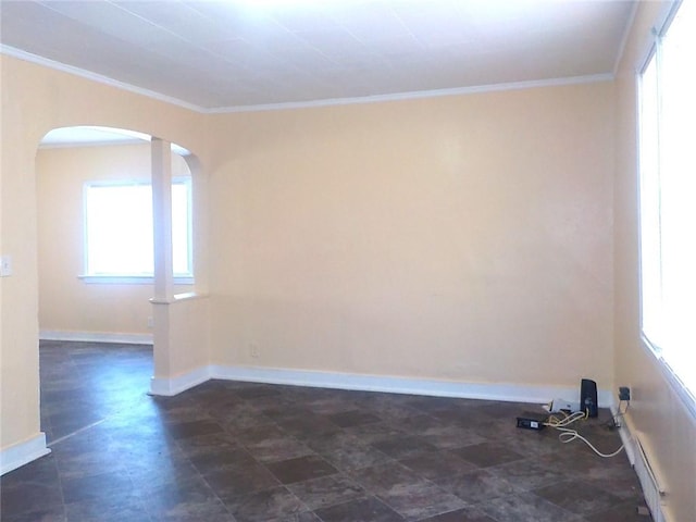 empty room featuring ornamental molding and plenty of natural light