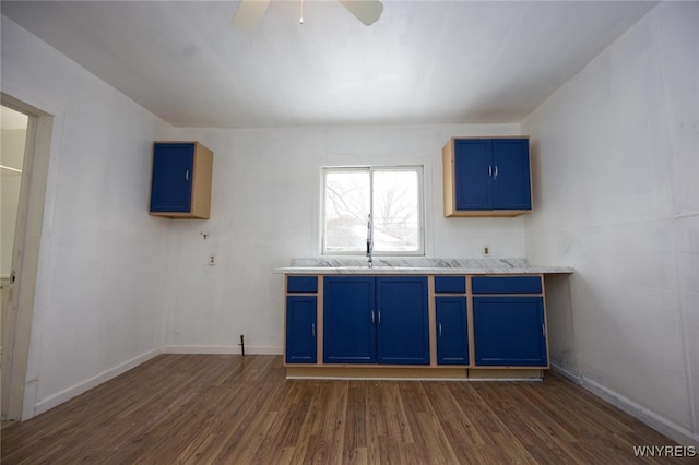 interior space with a sink, ceiling fan, dark wood finished floors, and baseboards