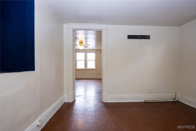 spare room with ceiling fan, wood finished floors, and baseboards