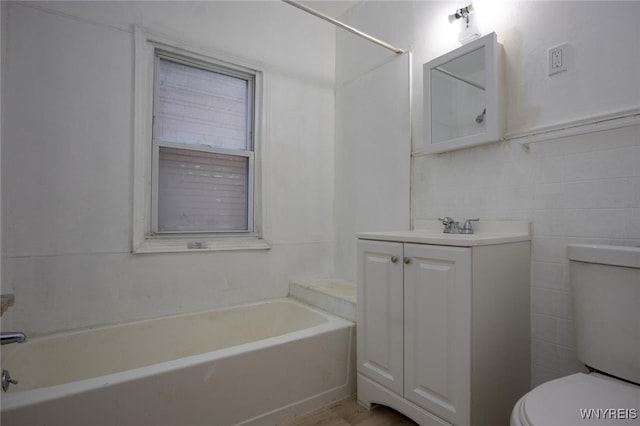 full bathroom with tile walls, vanity, toilet, and a tub