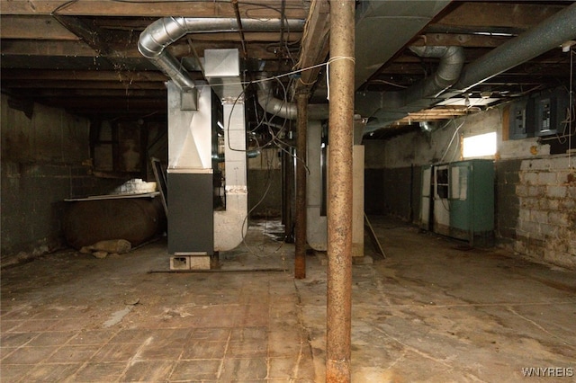 unfinished basement featuring heating unit and electric panel