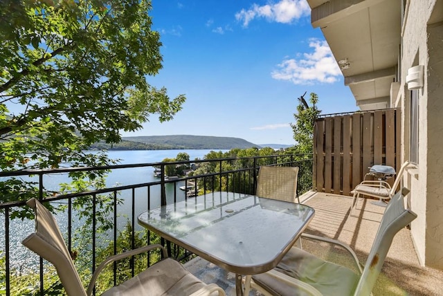 balcony featuring a water and mountain view