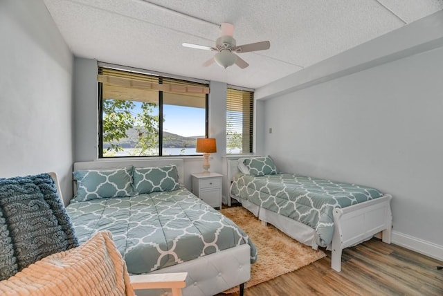 7 Cliffside Dr, South Bristol, NY 14424 - bedroom with hardwood / wood-style flooring, ceiling fan, a water view, and a textured ceiling