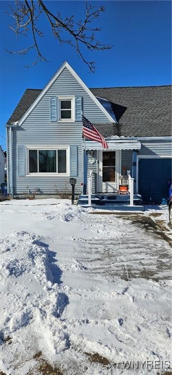 view of front of home with roof with shingles and an attached garage