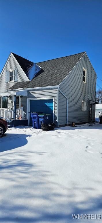 snow covered property featuring a garage