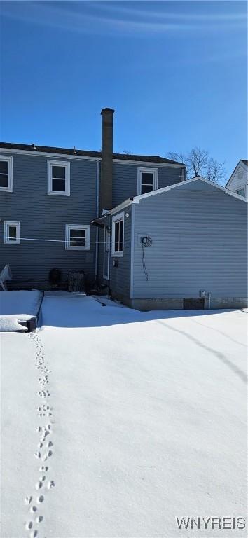 view of snow covered back of property