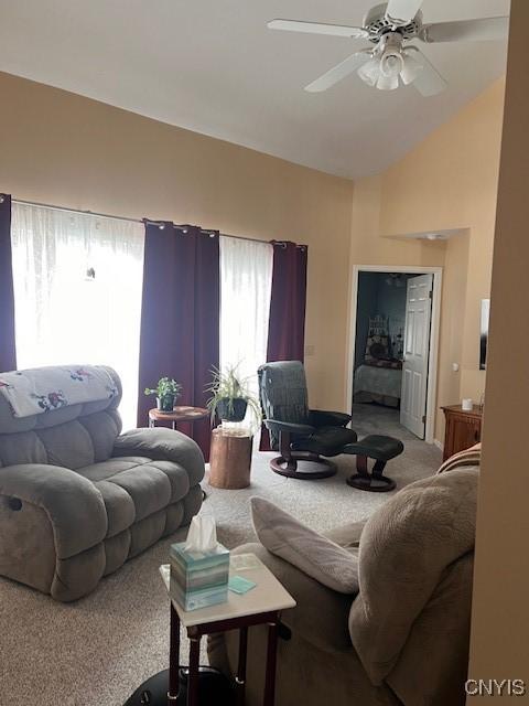 living room featuring ceiling fan, lofted ceiling, and carpet